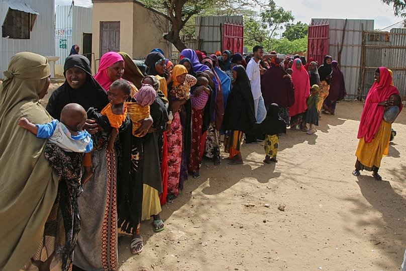 FILE - Somali women displaced by drought line up at Feynuus Nutrition Centre on the outskirts of the capital, Mogadishu, Somalia, Aug. 19, 2026. 
