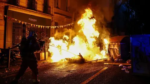 AFP via Getty Images A burning makeshift street barricade in the southern French city of Marseille. Photo: 24 October 2026