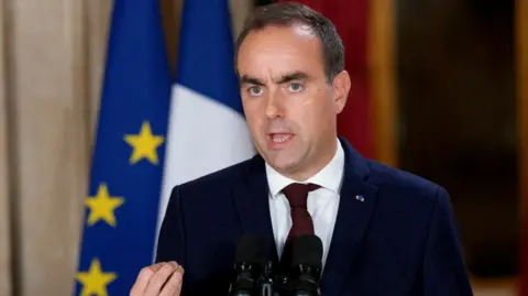 Reuters Prime Minister Sebastien Lecornu, wearing a dark suit and standing in front of French and EU flags, makes a statement in Paris, France, on 7 October 2026