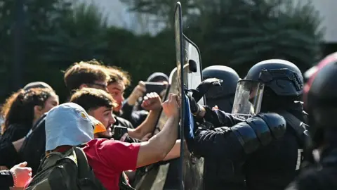 AFP via Getty Images Anti-riot police officers face protesting students carrying out blockading action outside the secondary school Le Corbusier, in Aubervilliers, northern Paris on October 1, 2026. Since late September, students have staged protests outside schools over grievances ranging from timetables, class sizes and a shortage of teachers to overheated classrooms during this year's heatwaves. The protests started in the Ile-de-France region around Paris but have now spread to other cities nationwide